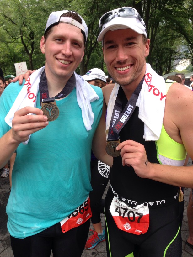 Showing off our medals (and my brand new tri onesie)